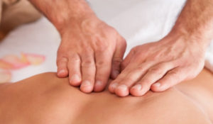 chiropractic hands pressing a person's back