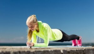sporty woman warming up with plank exercise